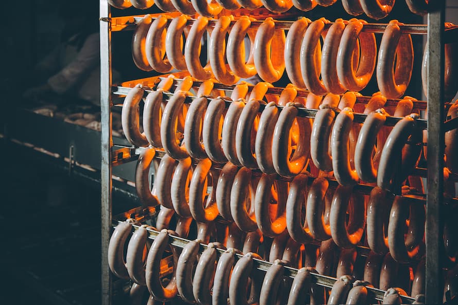 rack of sausage in food plant how sausage is made